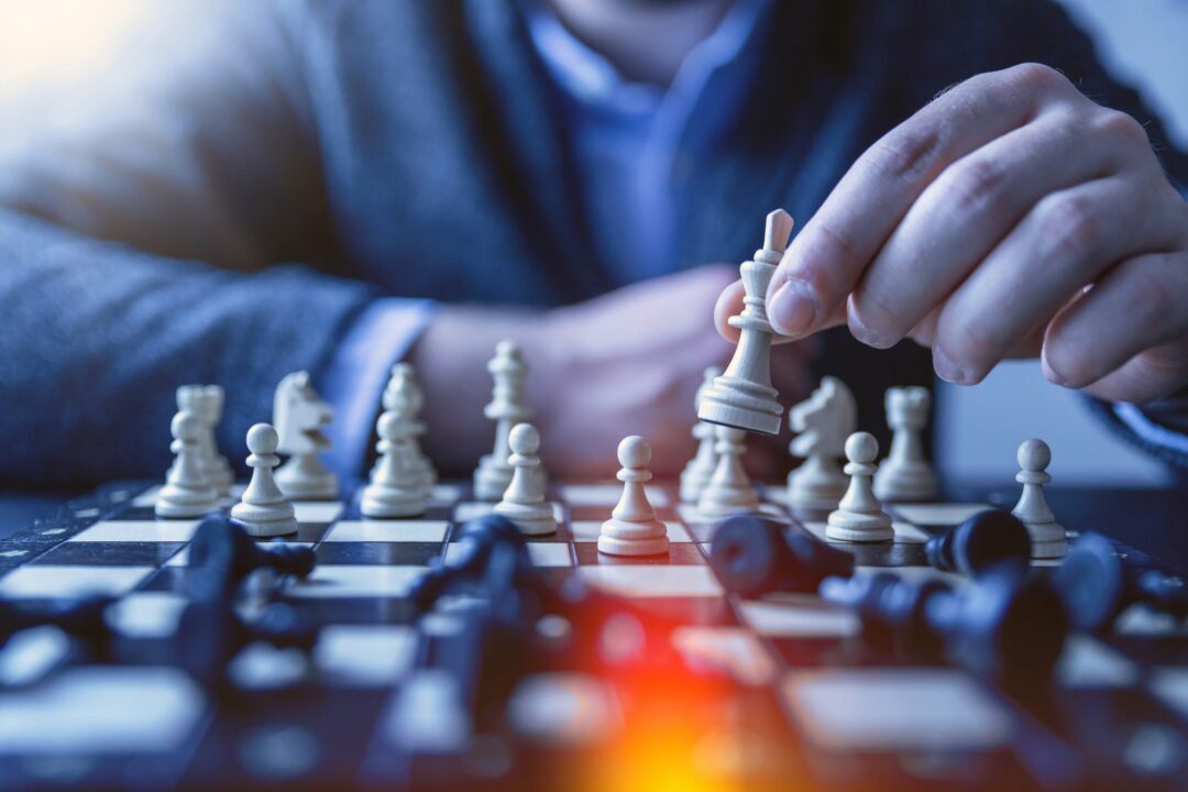 | itvibes Close Up of a Man Moving a Chess Piece on a Chess Board