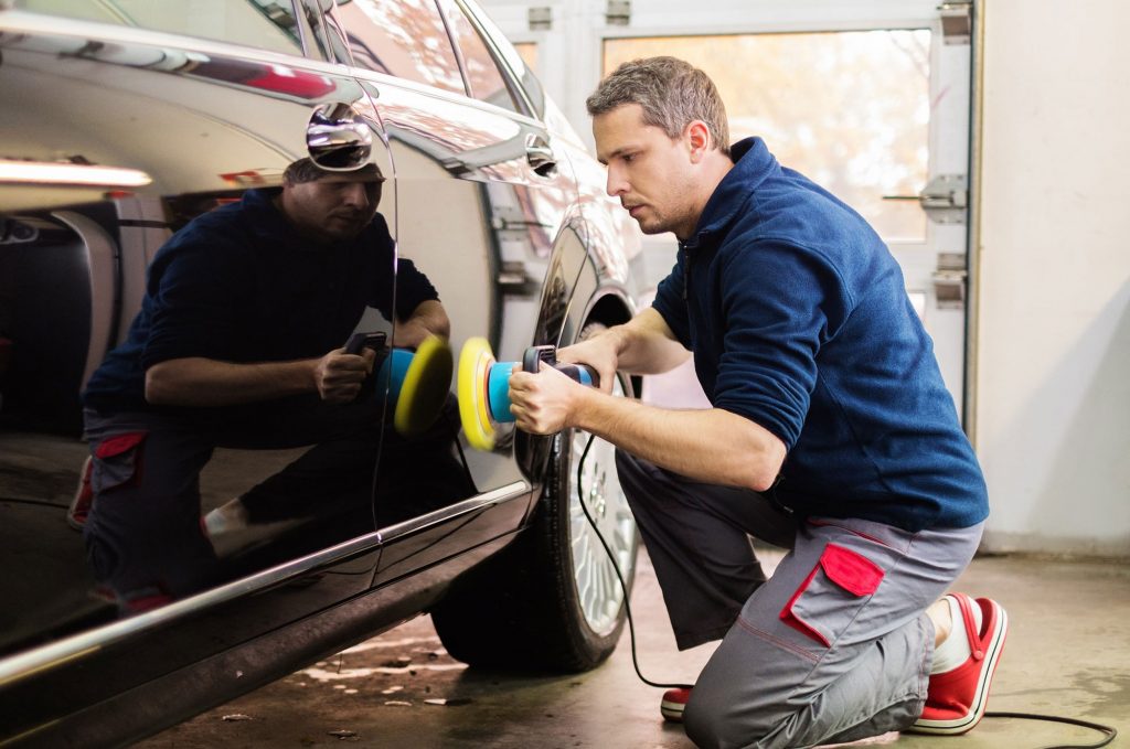 man buffing car in shop